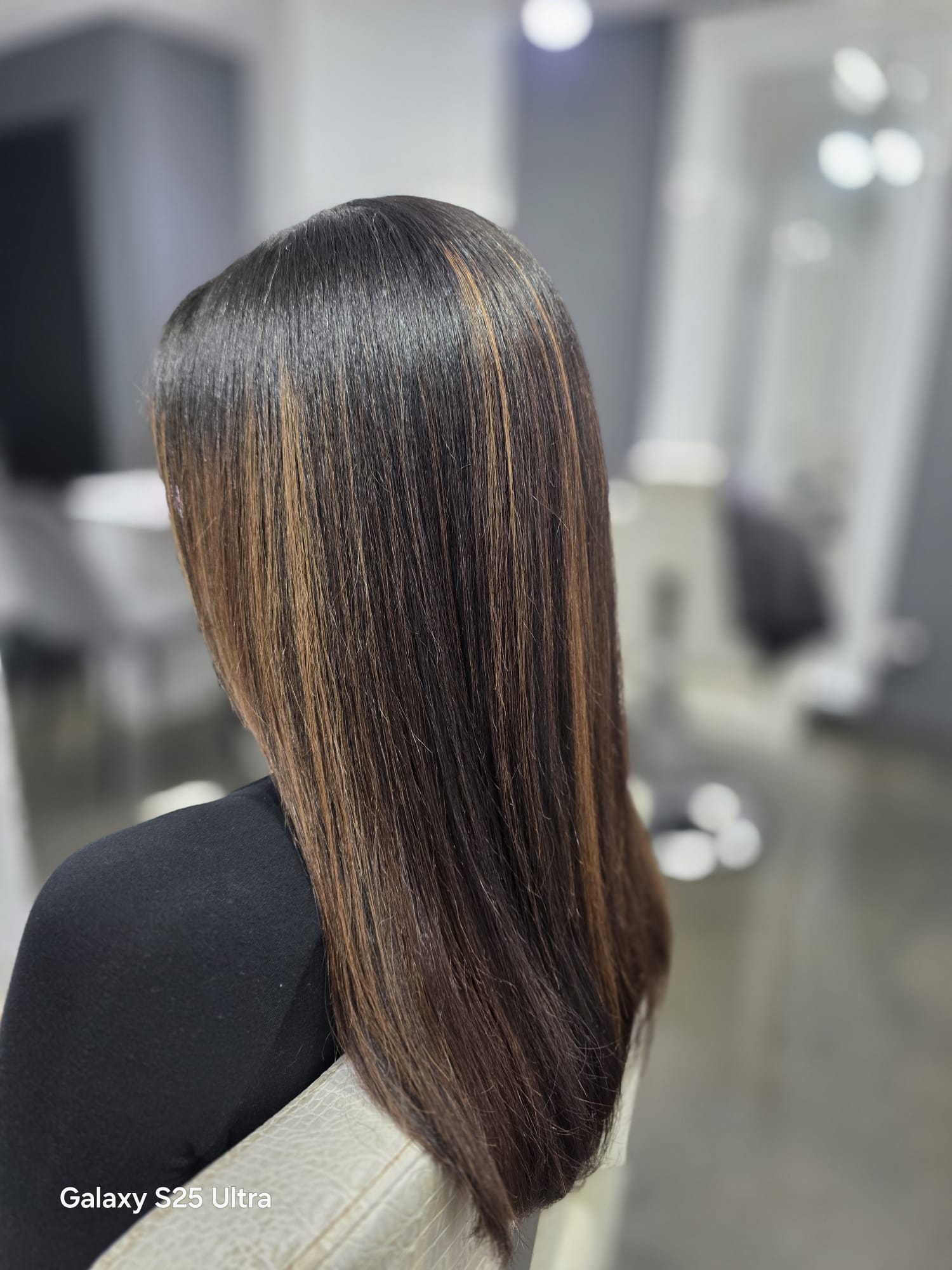Stylist shaping a client's hair for a polished finish